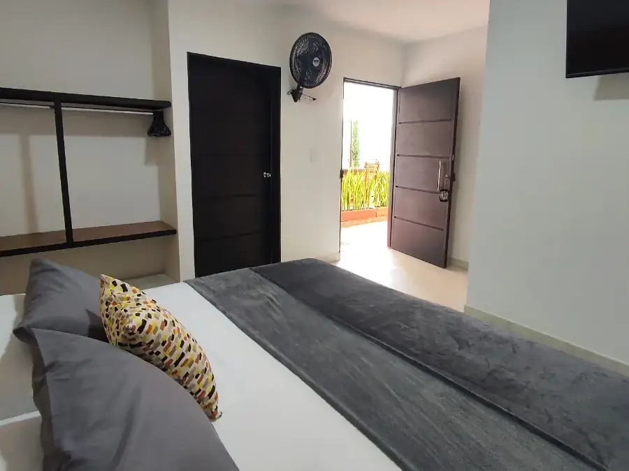 Habitación Doble de Origen con cama queen, televisor y ventilador