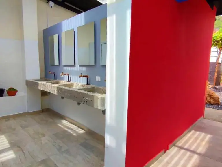 Lavamanos del baño compartido que usa la Grupal para 8 de Origen