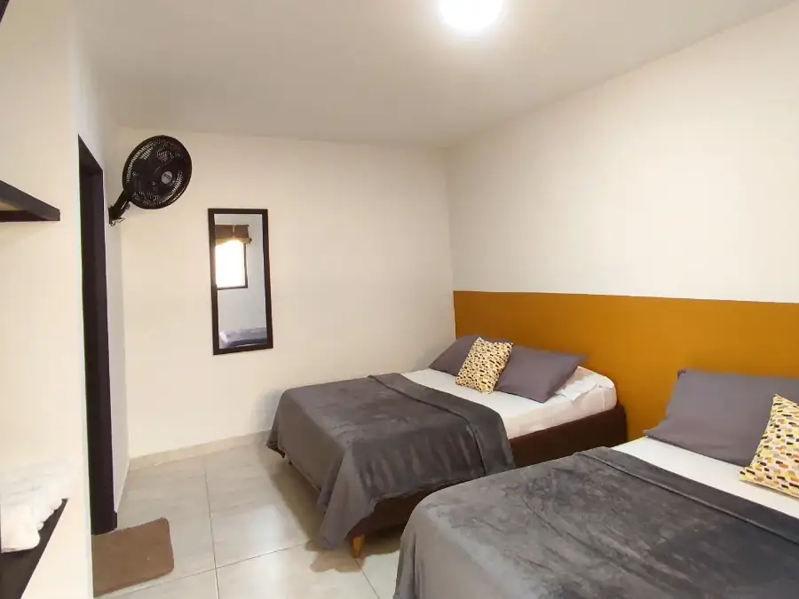 Habitación Twin de Origen con dos camas dobles y cabecero mostaza