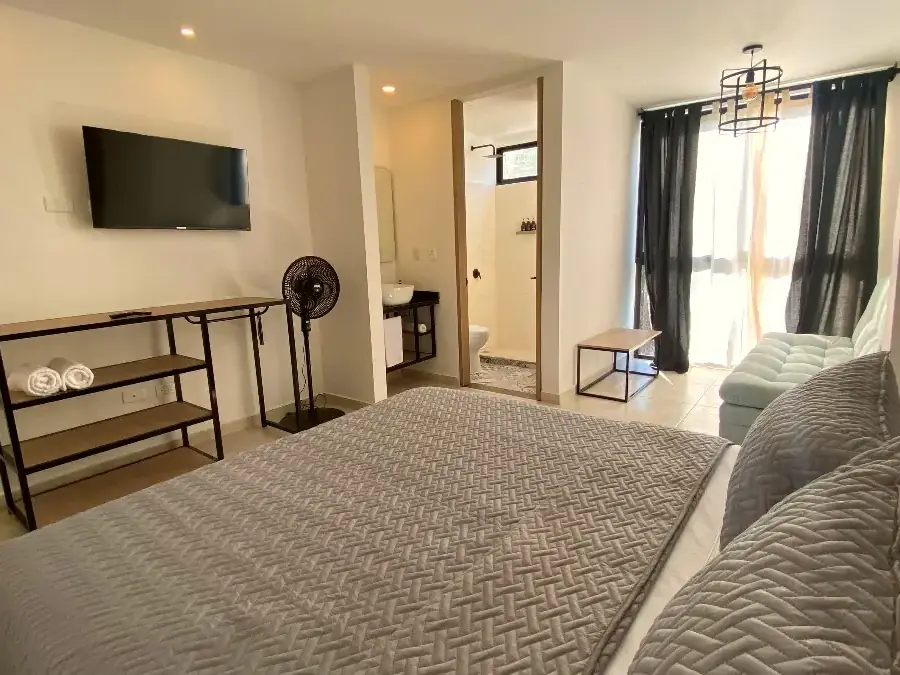Doble con vista a la calle de Del Río, con su cama y la puerta del baño privado