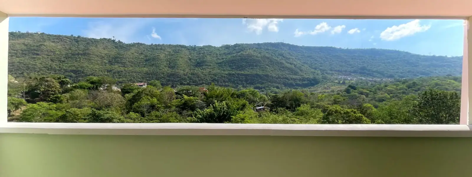 Montañas cubiertas de bosque vistas a través de una ventana ancha de Del Río